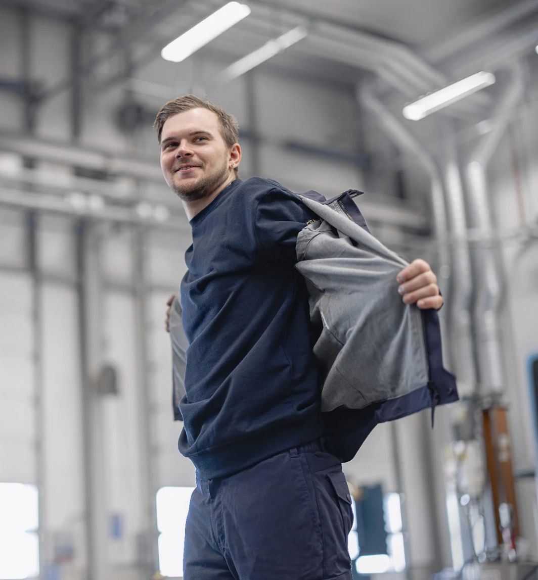 Ein Mann probiert eine Arbeitsjacke an